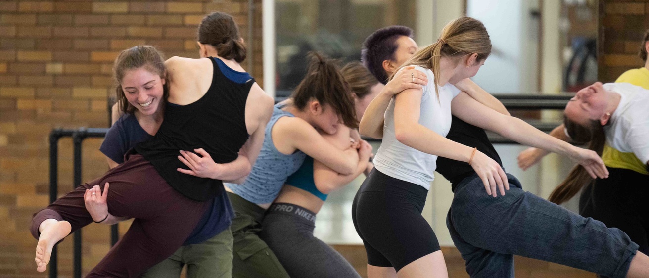 Student dancers exploring movement in Halsey Hall gym in workshop with Pilobolus