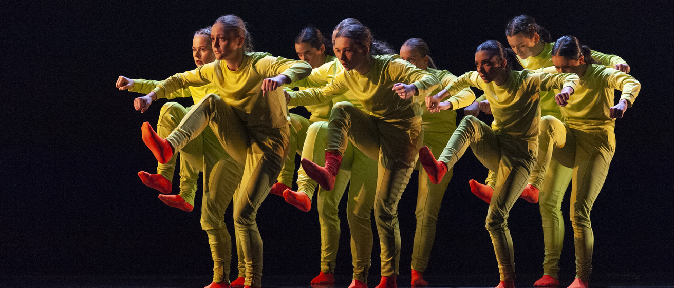 group of dancers dressed in yellow with orange socks