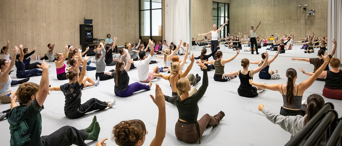 A large group of UI Dance students in a master class with UI Alum Jesse Factor before his Hancher performance later in the year